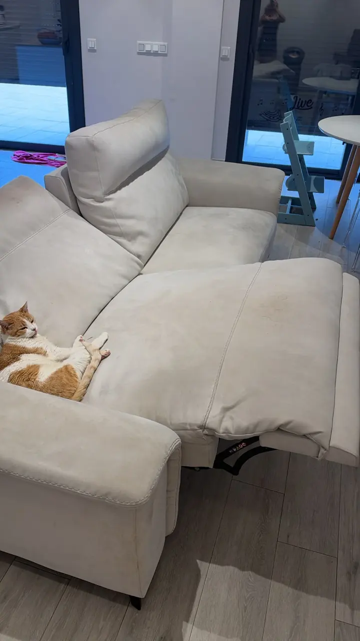 Asiento extensible de un sofá blanco con marcas amarillentas antes de la limpieza