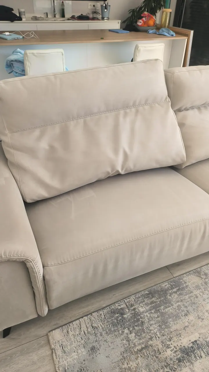 Asiento y respaldo de un sofá blanco después de la limpieza