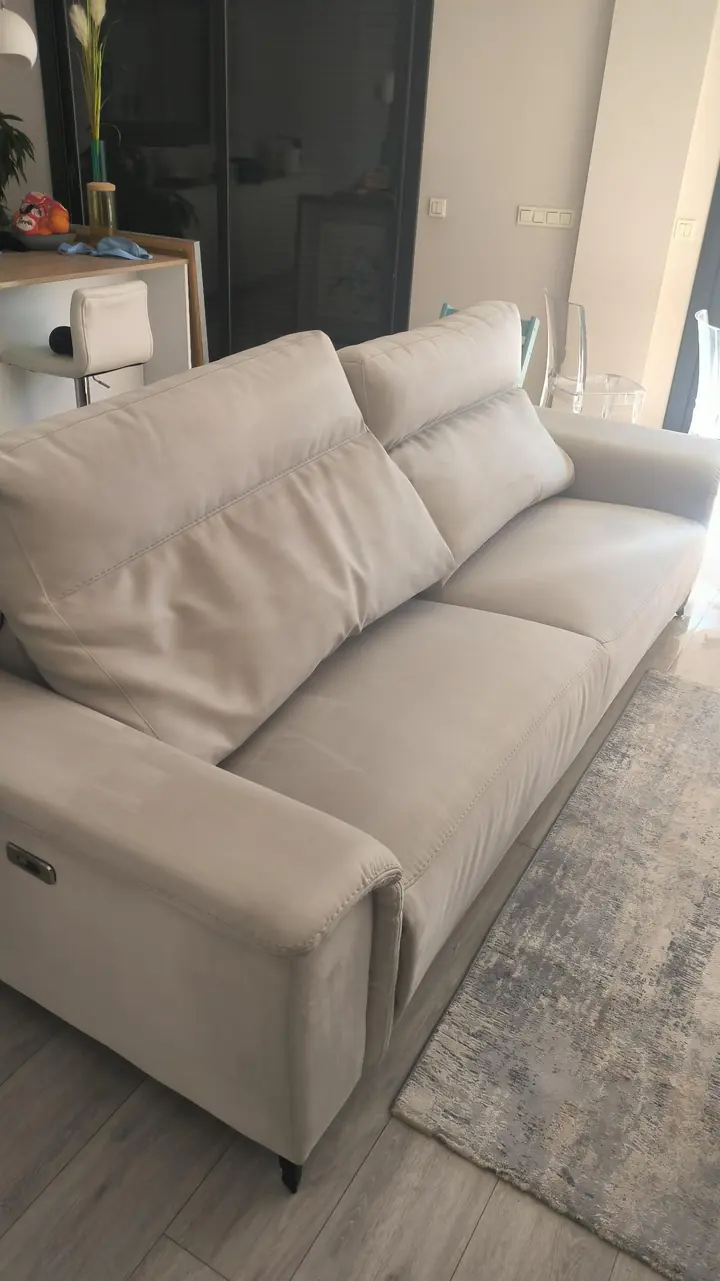Reposabrazos y lateral de un sofá blanco limpios después de la limpieza en Peralta