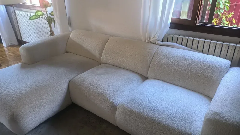 Sofá chaise longue de tapicería clara antes de la limpieza en Beriáin